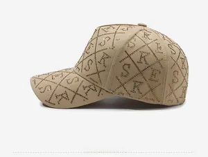 Détail de casquette beige avec motif de strass en losange et lettres métalliques