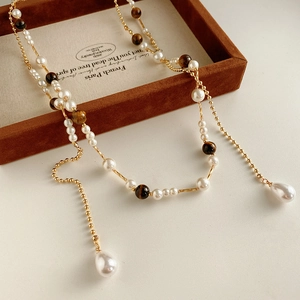 Macro view of multi-layer pearl necklace with tiger eye stone on a vintage jewelry box