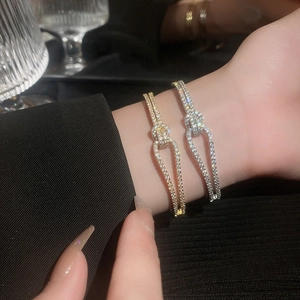 Macro-opname van goud- en zilverkleurige armbanden met fonkelende zirkonia-pavé details