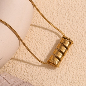 Close-up of 18K gold plated spiral spring pendant on a sleek snake chain necklace