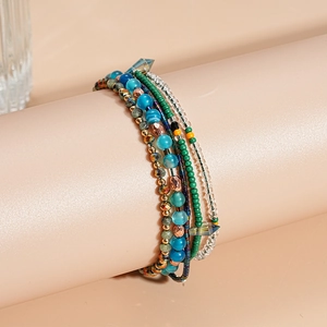 Detail van een bohemian meerlagige armband met blauwe en groene glazen agaat kralen