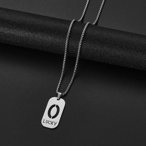 Close-up of silver lucky pendant on a textured post with a polished stainless steel chain