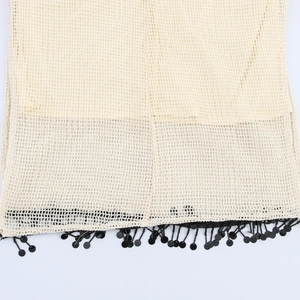 Beiges Häkelkleid mit Lochmuster-Design und schwarzem Pailletten-Fransen-Saumdetail