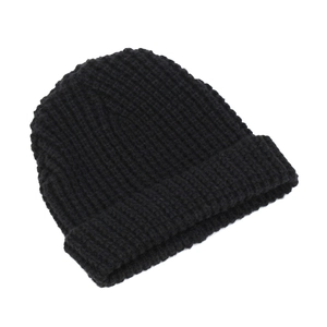 Close-up of thick ribbed texture and wide folded cuff on a black knit beanie hat