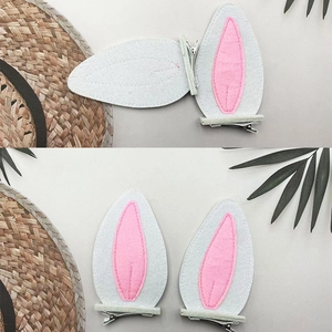 Detail of pink and white bunny ear hair clips with metal alligator base and felt texture