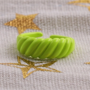 Macro shot of green enamel twisted rope ring with adjustable open design on fabric