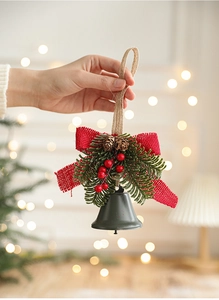 Detail of Christmas metal bell hanger with red bow pine needles and berries
