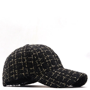 Détail de la casquette de baseball en tweed noir avec fil doré et texture à carreaux
