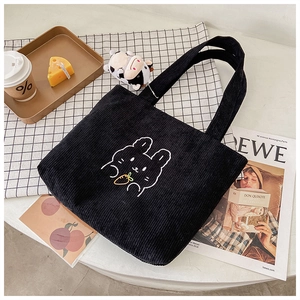 Close-up of black corduroy tote bag with cute cartoon rabbit embroidery detail