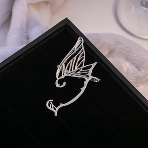 Detailed macro shot of silver butterfly wing ear cuff in a black velvet jewelry box