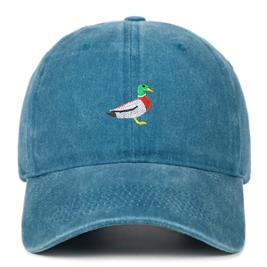 Close-up of green duck embroidery on vintage washed blue cotton baseball cap fabric