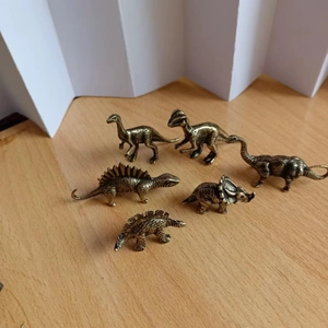 Detail view of 6 miniature bronze dinosaur figurines with vintage scale textures