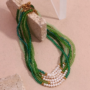 Handmade beaded necklace with green faceted crystals and fresh water pearls on stone