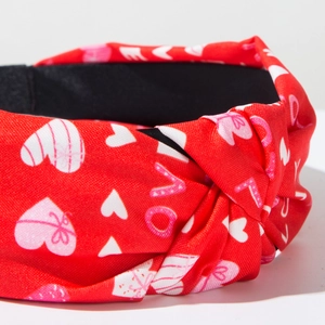 Detail of red Valentine's headband with love heart prints and twisted knot design