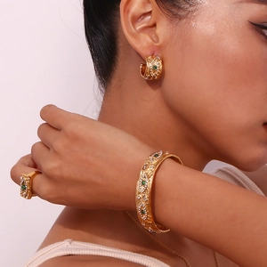 Close-up of elegant gold jewelry set with green malachite and zircon on a model