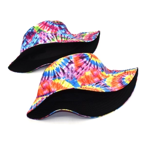 Detail of reversible bucket hat showing colorful tie-dye print and black inner lining side