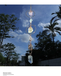 Hanging suncatcher with amethyst and citrine stones against a clear blue sky background