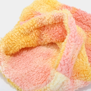 Detail of soft tie-dye sherpa fleece fabric in pink and yellow for winter neck warmer