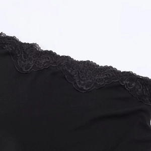 Gros plan sur les détails en dentelle noire et le tissu en maille de la robe