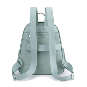 Rear view of mint green nylon backpack showing anti-theft zipper pocket and adjustable straps