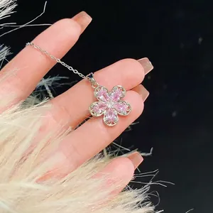 Elegant stainless steel necklace featuring a pink zircon flower pendant held in hand