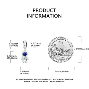 Detailed size comparison of silver astronaut bear charm next to a coin for scale