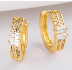 Detail shot of gold earring hoop with rectangular and round cubic zirconia stones
