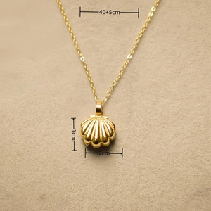 Macro shot of gold shell locket pendant with dimensions 2x1cm and 40+5cm chain length