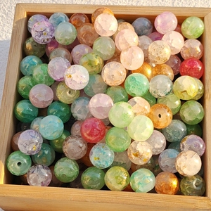 Macro shot of 8-10mm colorful ice-crackled glass beads for DIY jewelry in a wooden box