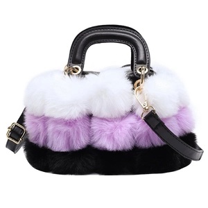 Detail of plush faux fur handbag featuring purple and white gradient and black leather strap