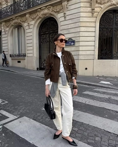 Scatto di moda di una donna con giacca in pelle scamosciata marrone e pantaloni beige