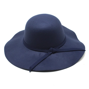 Close-up of navy blue thick felt fedora hat with elegant wavy brim and decorative band