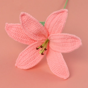 Macro detail of a handmade pink crochet lily flower made from premium soft yarn