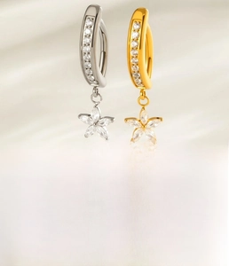 Detail eines Bauchnabelpiercings aus G23-Titan mit Zirkon-Blumenanhänger in Gold und Silber