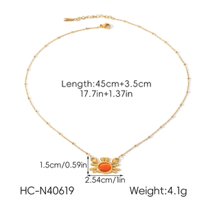 Détail du collier pendentif crabe en acier inoxydable or 18 carats et pierre orange