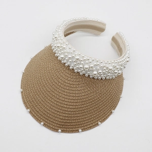 Detailed view of woven straw sun hat with elegant pearl embellishments on the brim