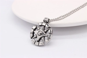 Détail du pendentif boussole rétro avec motif d'étoile sur une assiette blanche