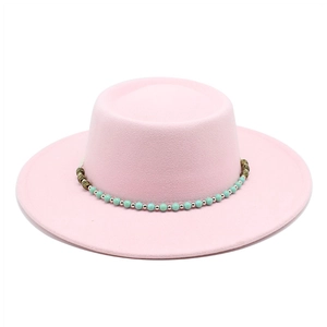 Pink flat-top boater hat featuring a turquoise beaded ethnic style decorative band