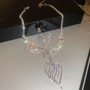Close-up of sparkling silver leaf necklace and earrings set with brilliant crystals
