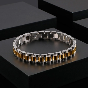 Detailed close-up of a silver and gold tone stainless steel watch-style metal bracelet
