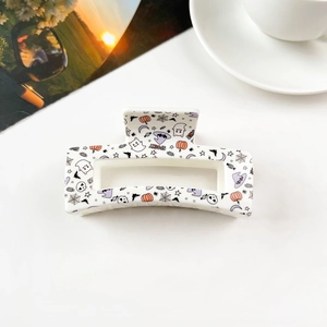 Detail of a rectangular Halloween hair claw clip with spooky pumpkins and ghosts prints