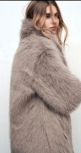 Detailed close-up of fluffy long-haired faux fur coat in mauve with soft texture