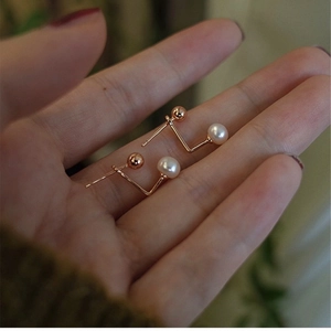 Minimalist freshwater pearl gold bead earrings for women held in hand