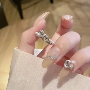 Elegant bow knot pearl open ring with cubic zirconia accents on a woman's hand