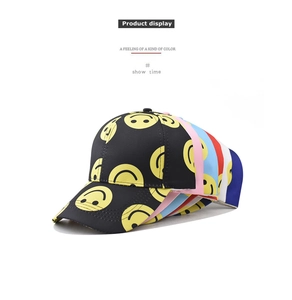 Stack of colorful cotton baseball caps with all-over smiley face prints in various colors