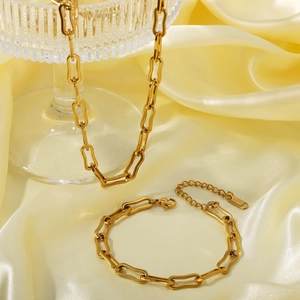Minimalist 18K gold plated stainless steel necklace and bracelet jewelry set on satin