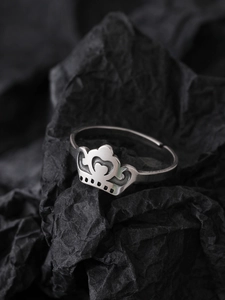 Detailed view of silver crown luminous ring on textured black paper background
