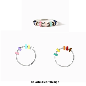 Macro view of rotatable colorful enamel cubes on silver stainless steel spinner rings