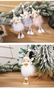Detail of plush angel Christmas ornaments with feather wings and sequin hats on wood base