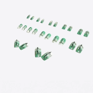 Detail of short emerald green gradient press-on nails with leaf veins and gold glitter